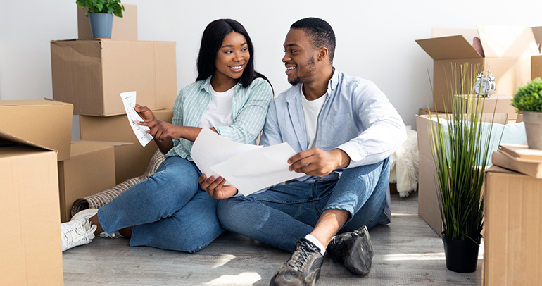 An image of a couple who just moved into a new house looking over their new utility bills