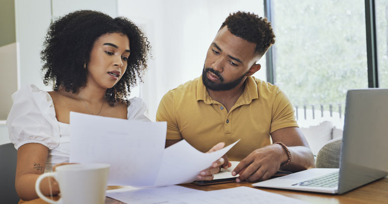 An image of a couple looking over their utility bill